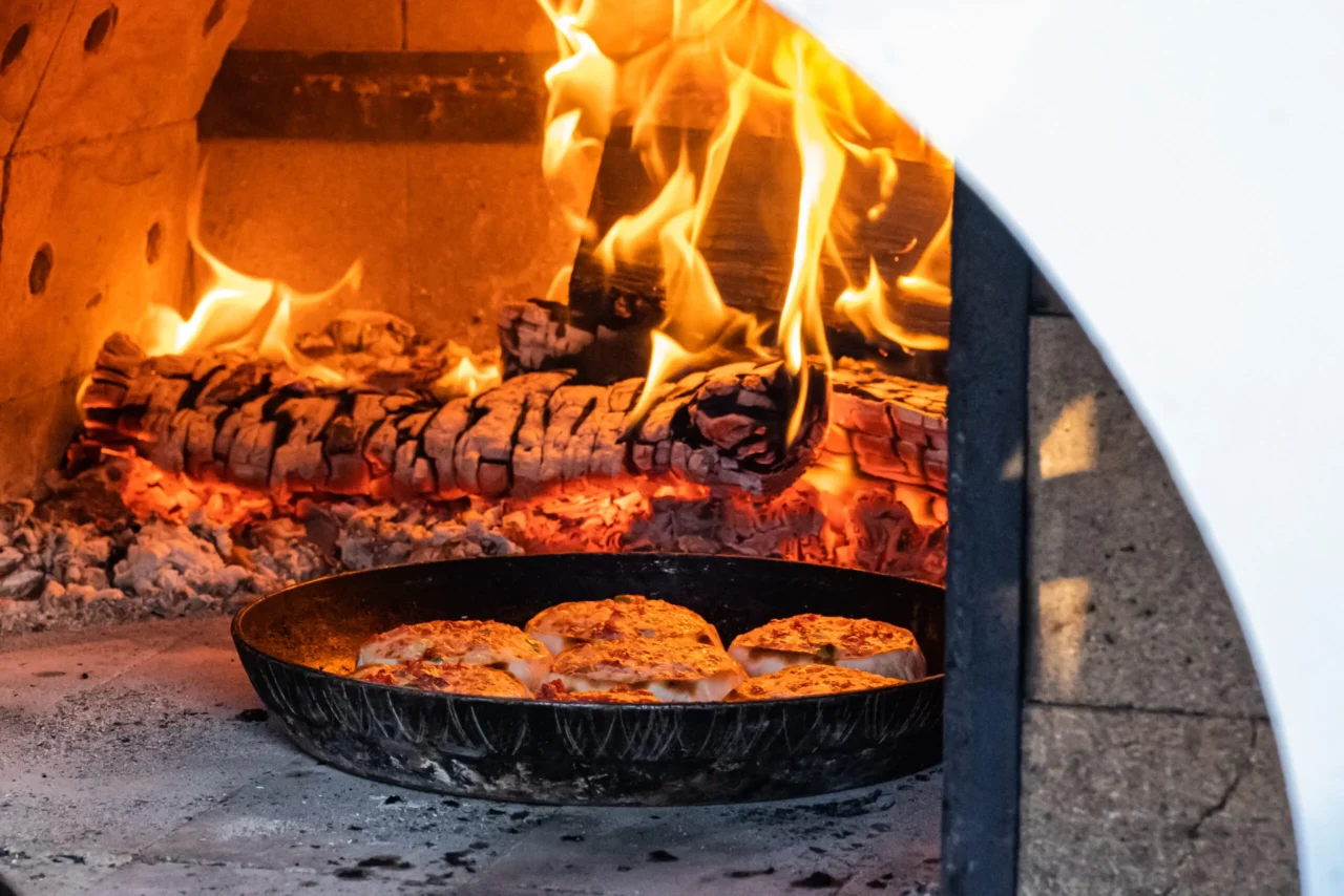 pizza oven with fire wood logs burning
